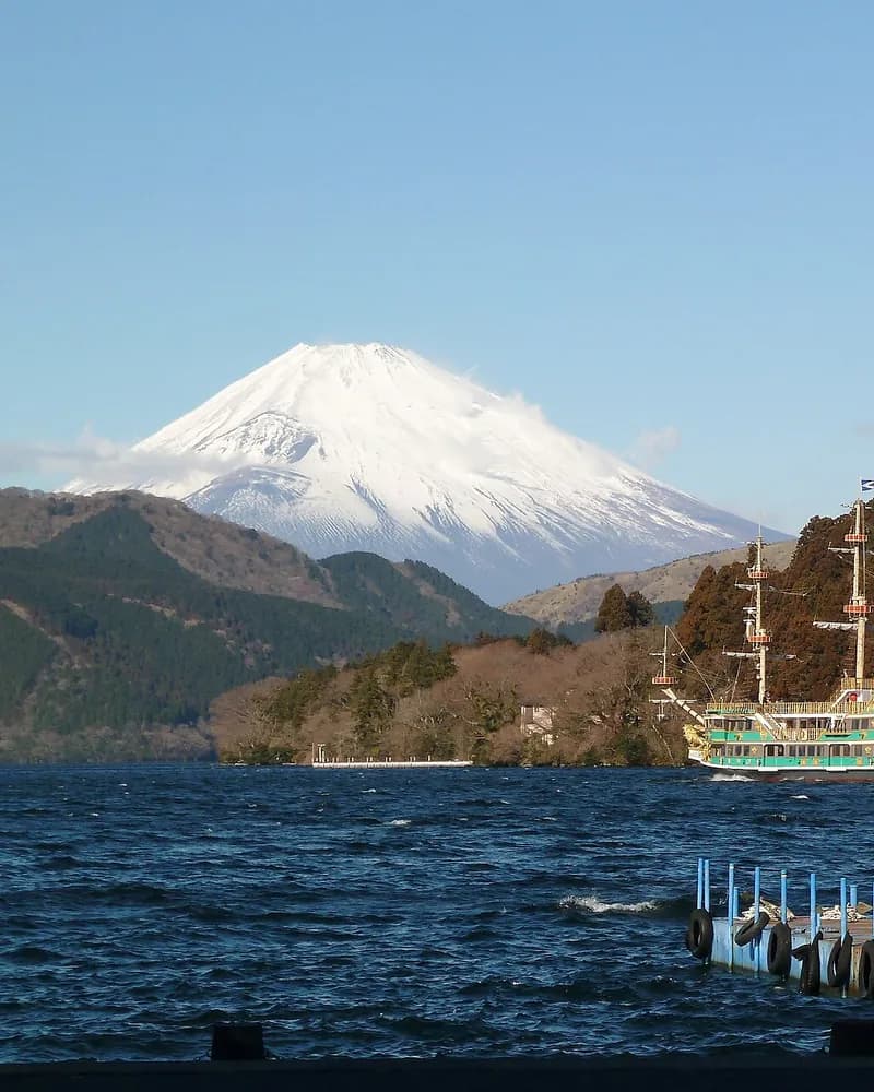 Snow-capped Mount Fuji over Lake Ashi with a Hakone sightseeing ship below