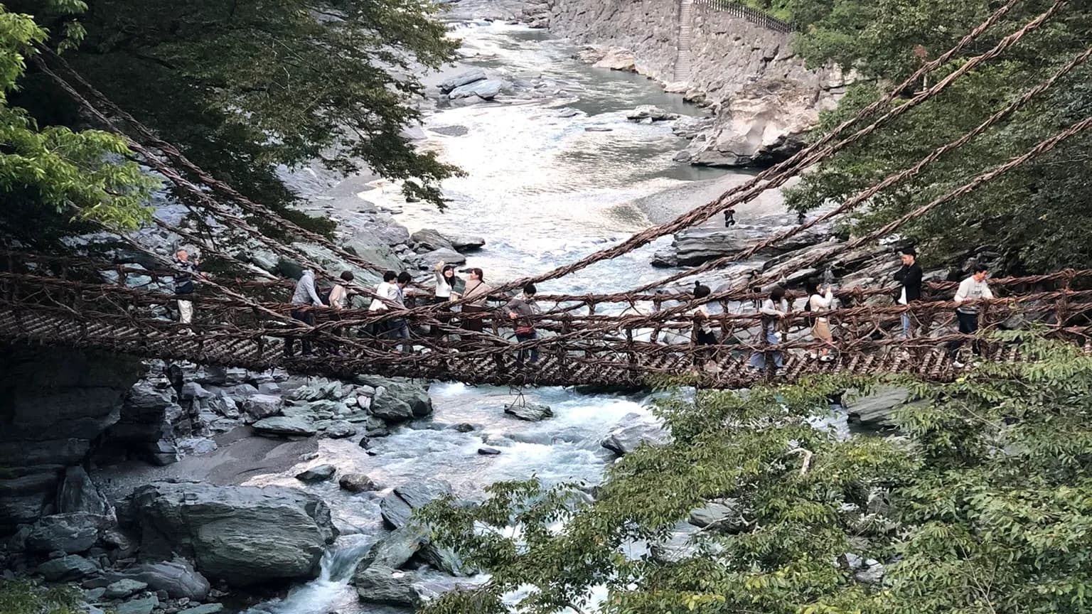 The Iya Kazurabashi vine bridge hanging low over a rocky, fast-flowing river in the Iya Valley, Tokushima